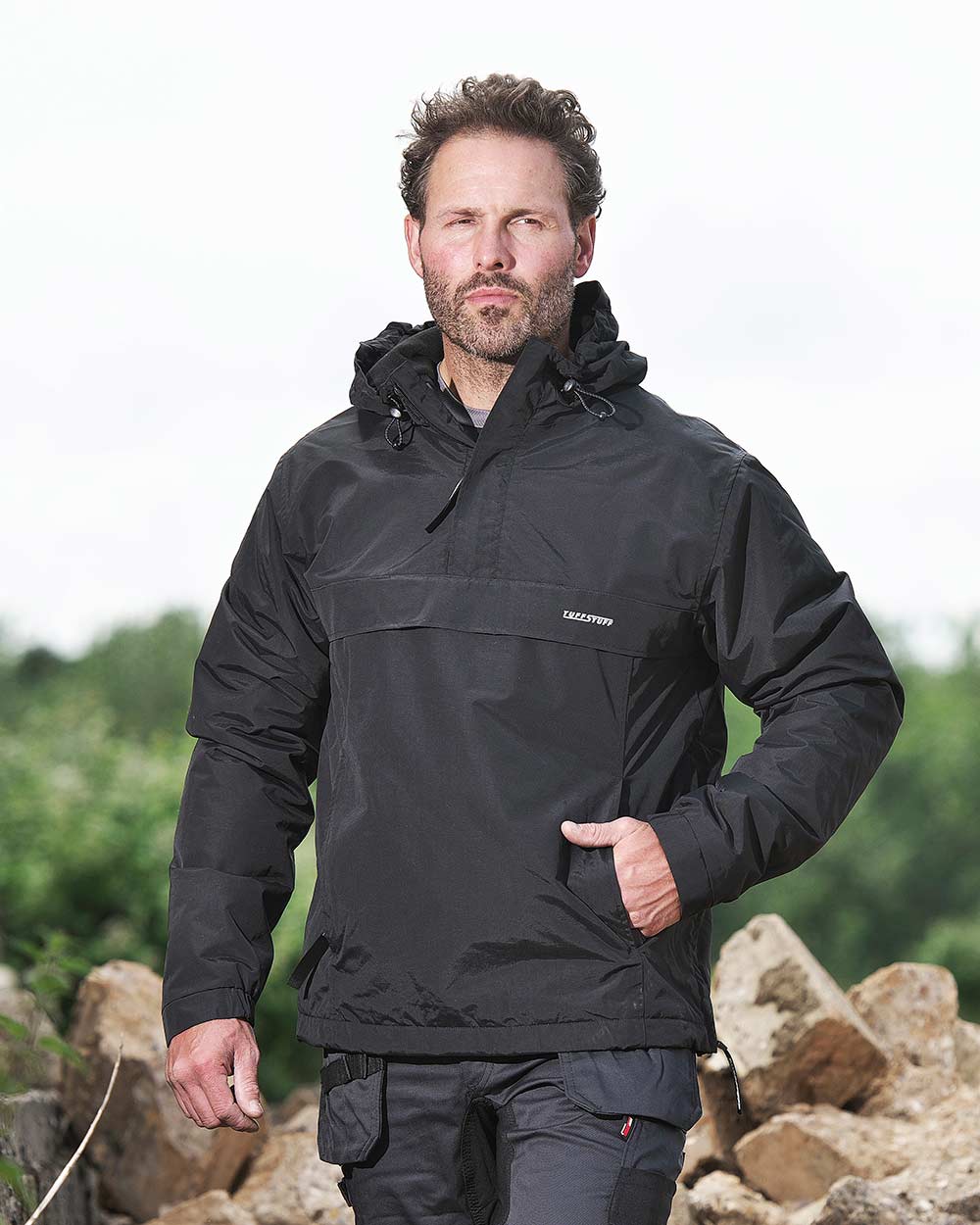 Black Coloured TuffStuff Sutherland Waterproof Windbreaker Smock On A Forest Background