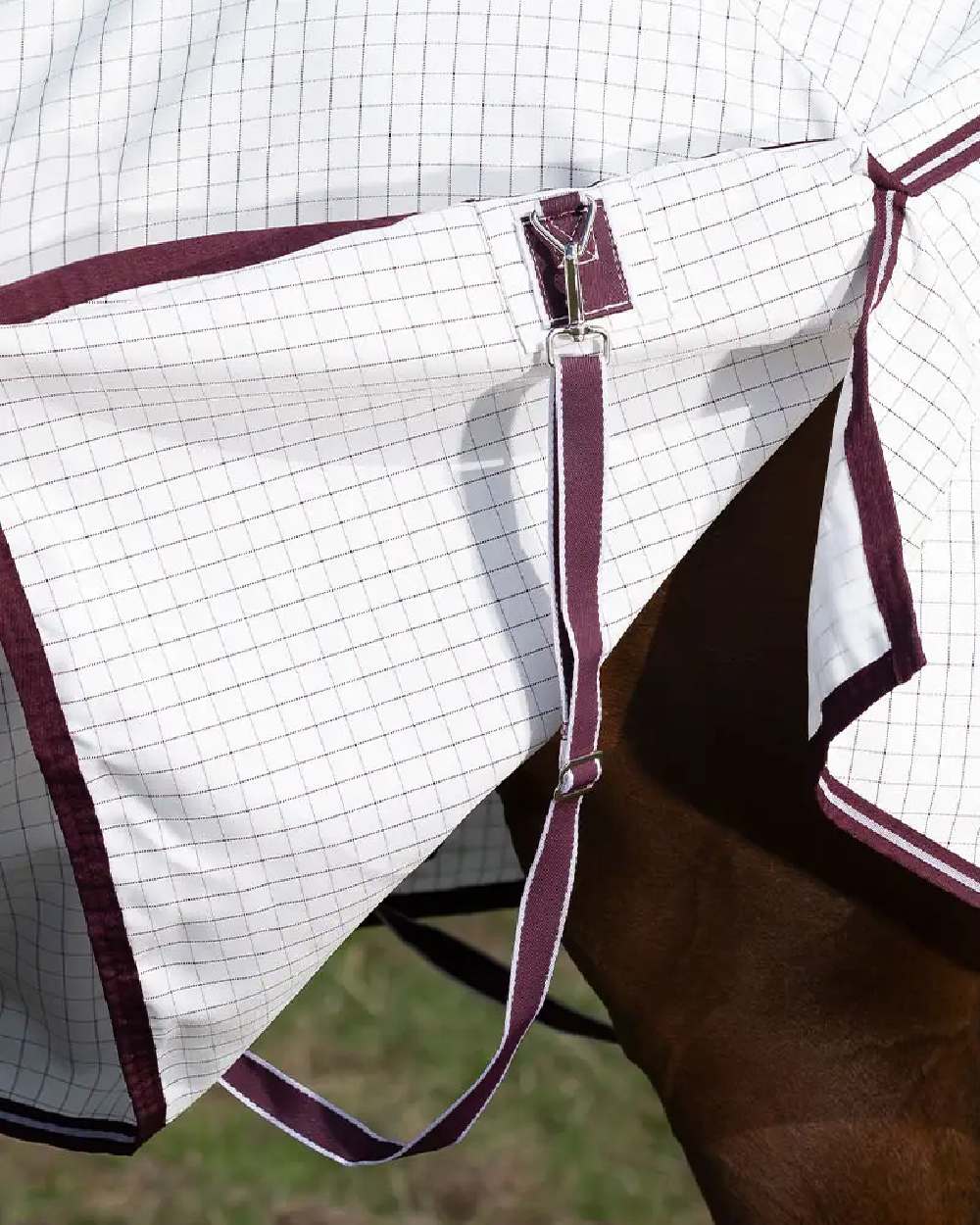 White maroon coloured WeatherBeeta Hybrid Seasons Combo Neck on blurry green background