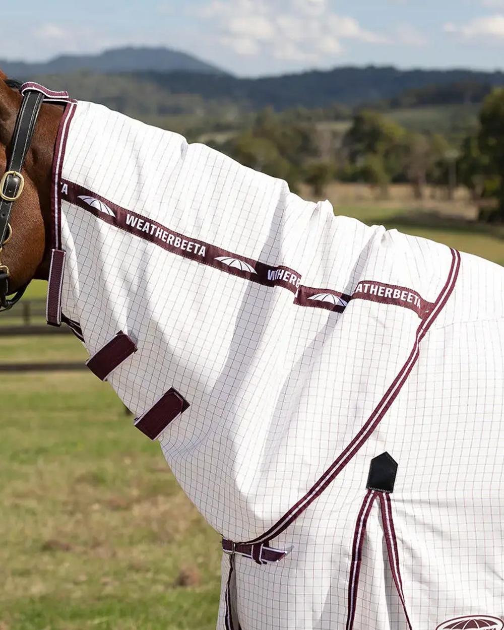 White maroon coloured WeatherBeeta Hybrid Seasons Combo Neck on blurry fiedl background