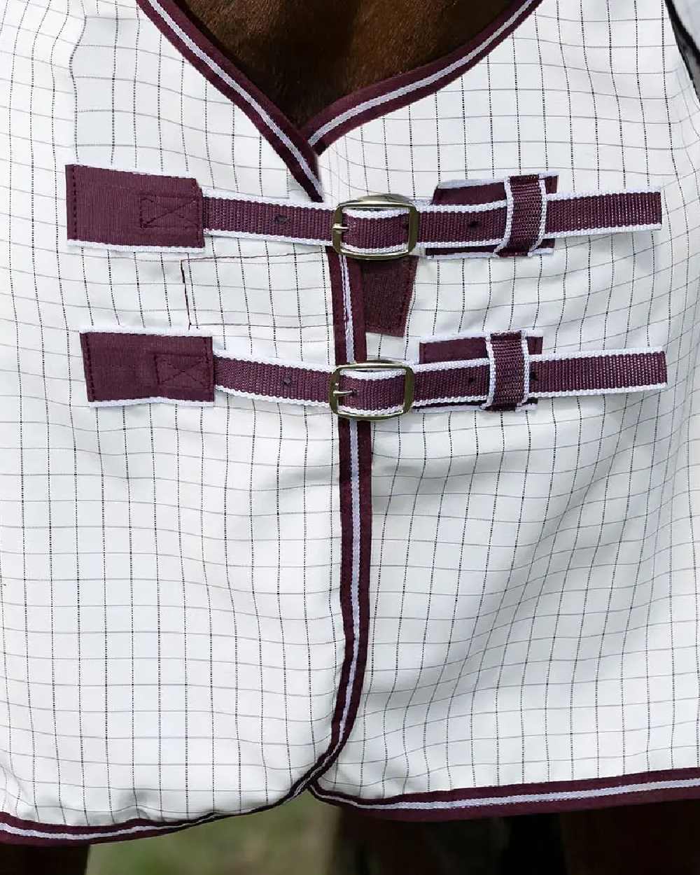 White maroon coloured WeatherBeeta Hybrid Seasons Combo Neck on blurry green background