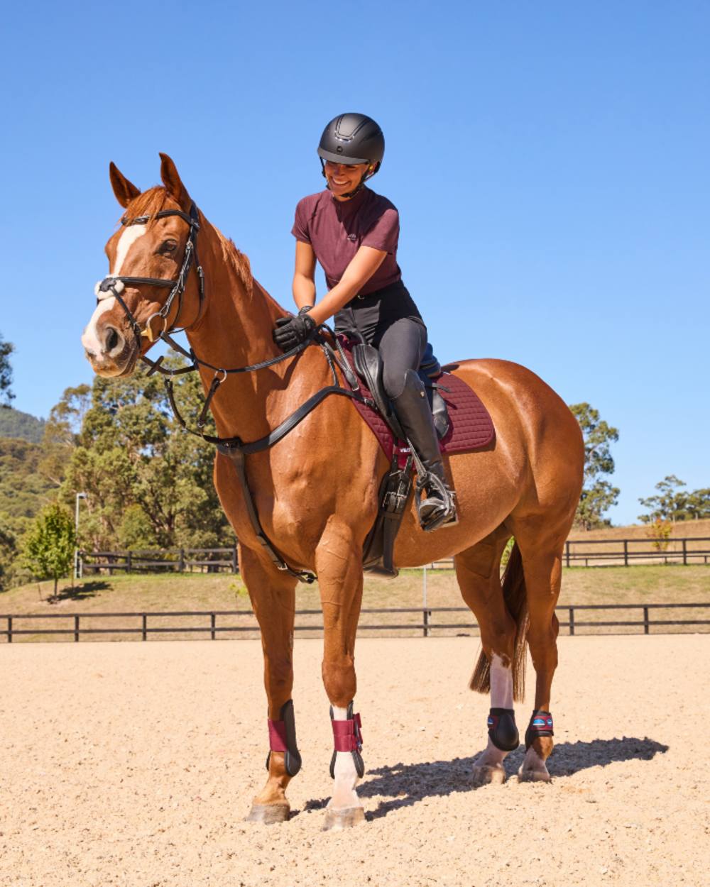 Burgundy Coloured WeatherBeeta Prime Air-Tec Jump Shaped Saddle Pad on horse background
