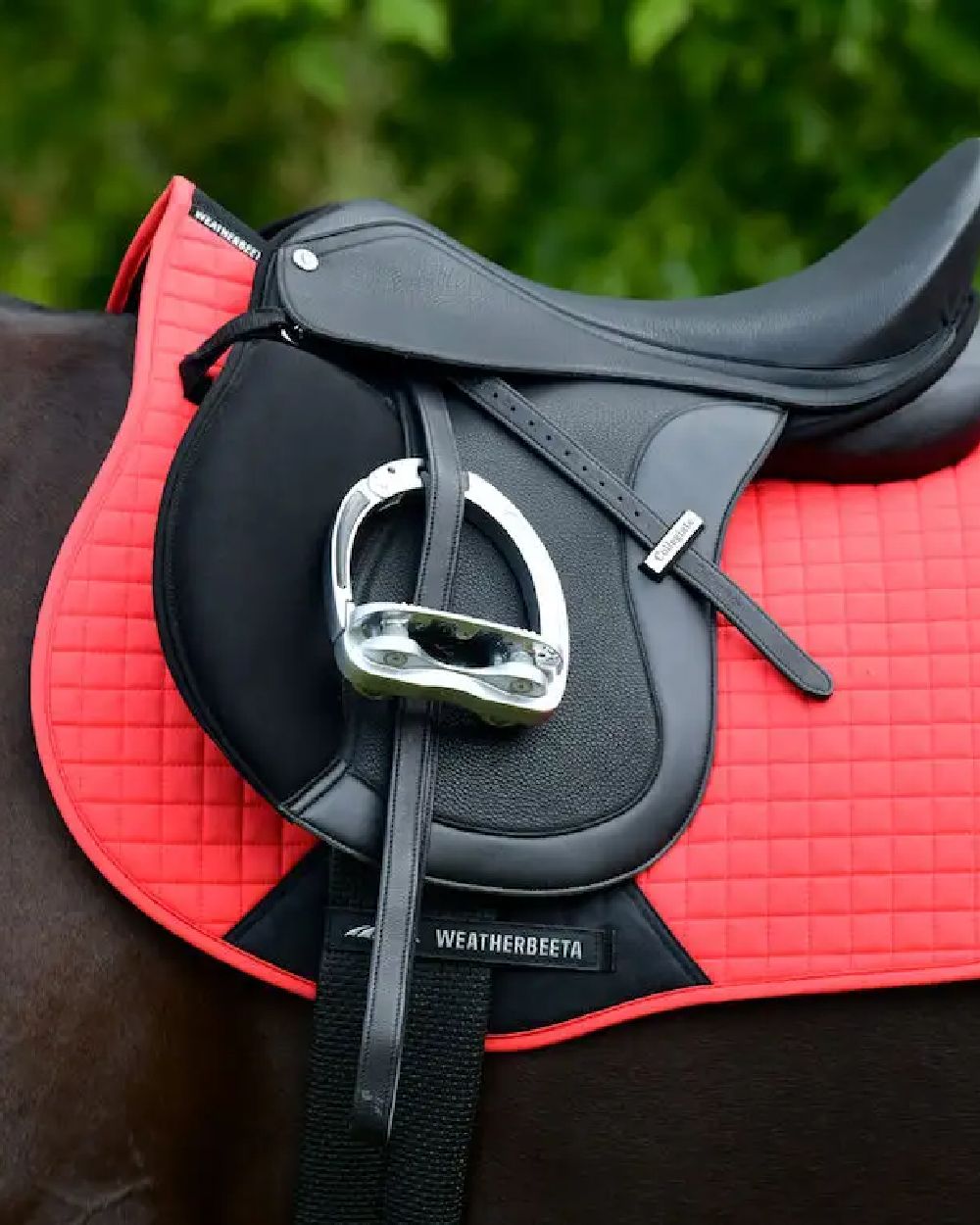 Bittersweet red coloured WeatherBeeta Prime All Purpose Saddle Pad on blurry background