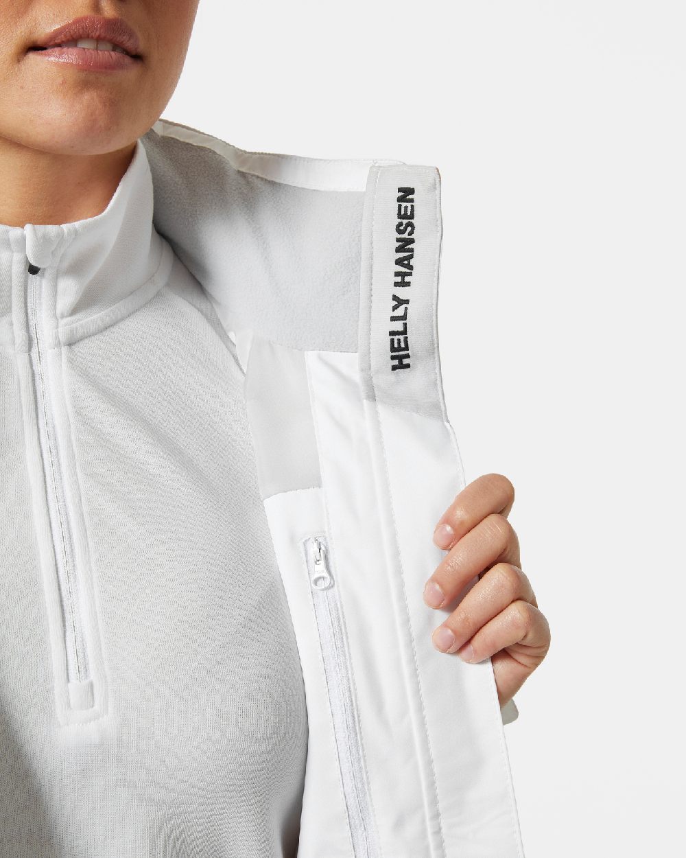 White coloured Helly Hansen womens crew hooded sailing jacket 2.0 on grey background
