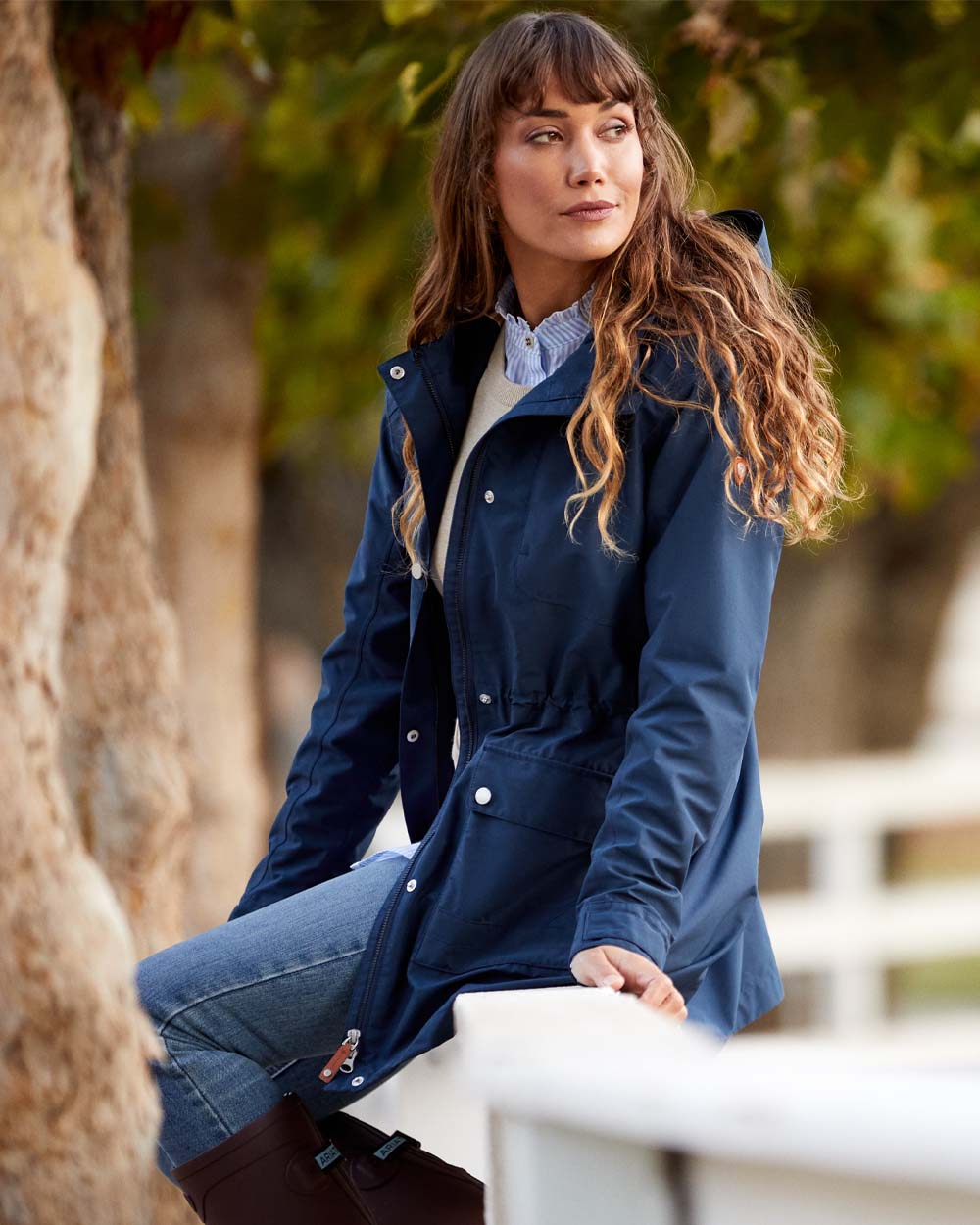 Navy coloured Ariat Womens Atherton Jacket on Blurry Trees background