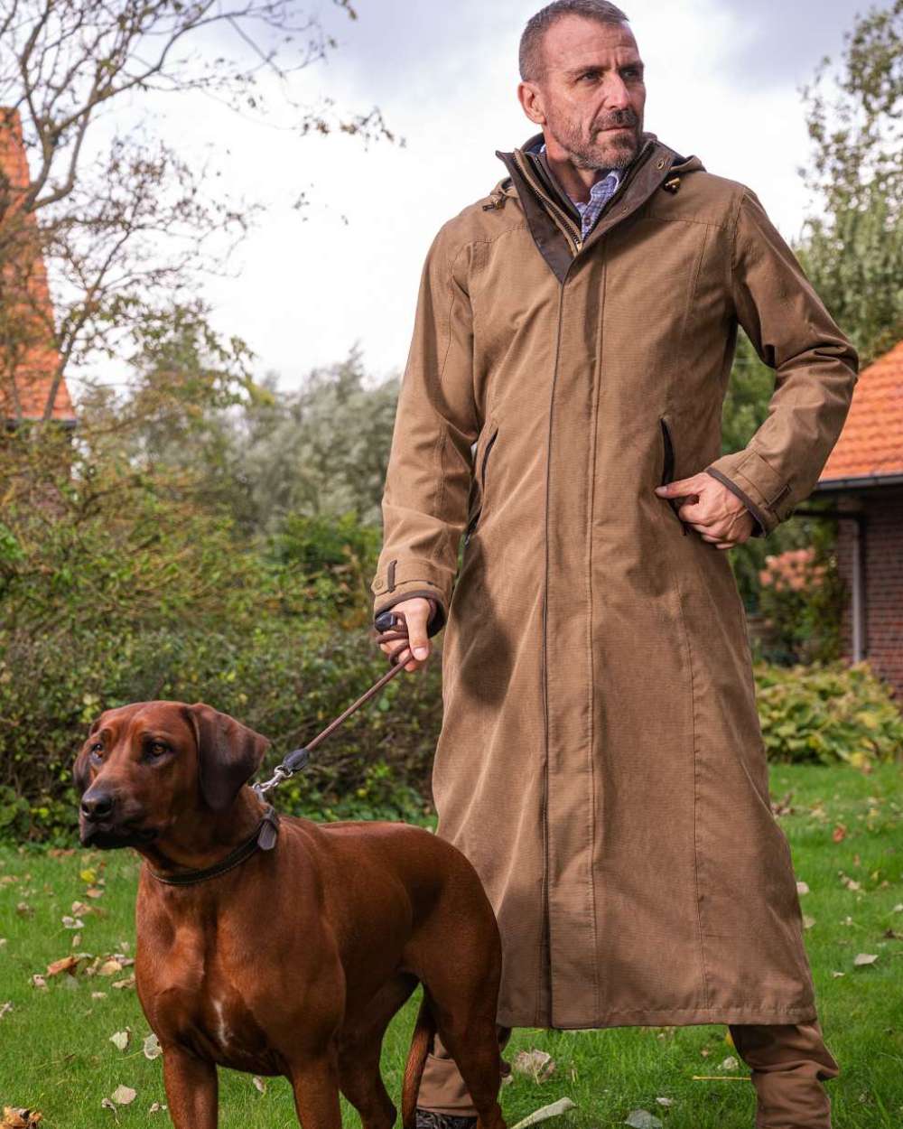 Camel Coloured Baleno Livingstone Long Waterproof Coat On A Backyard Background