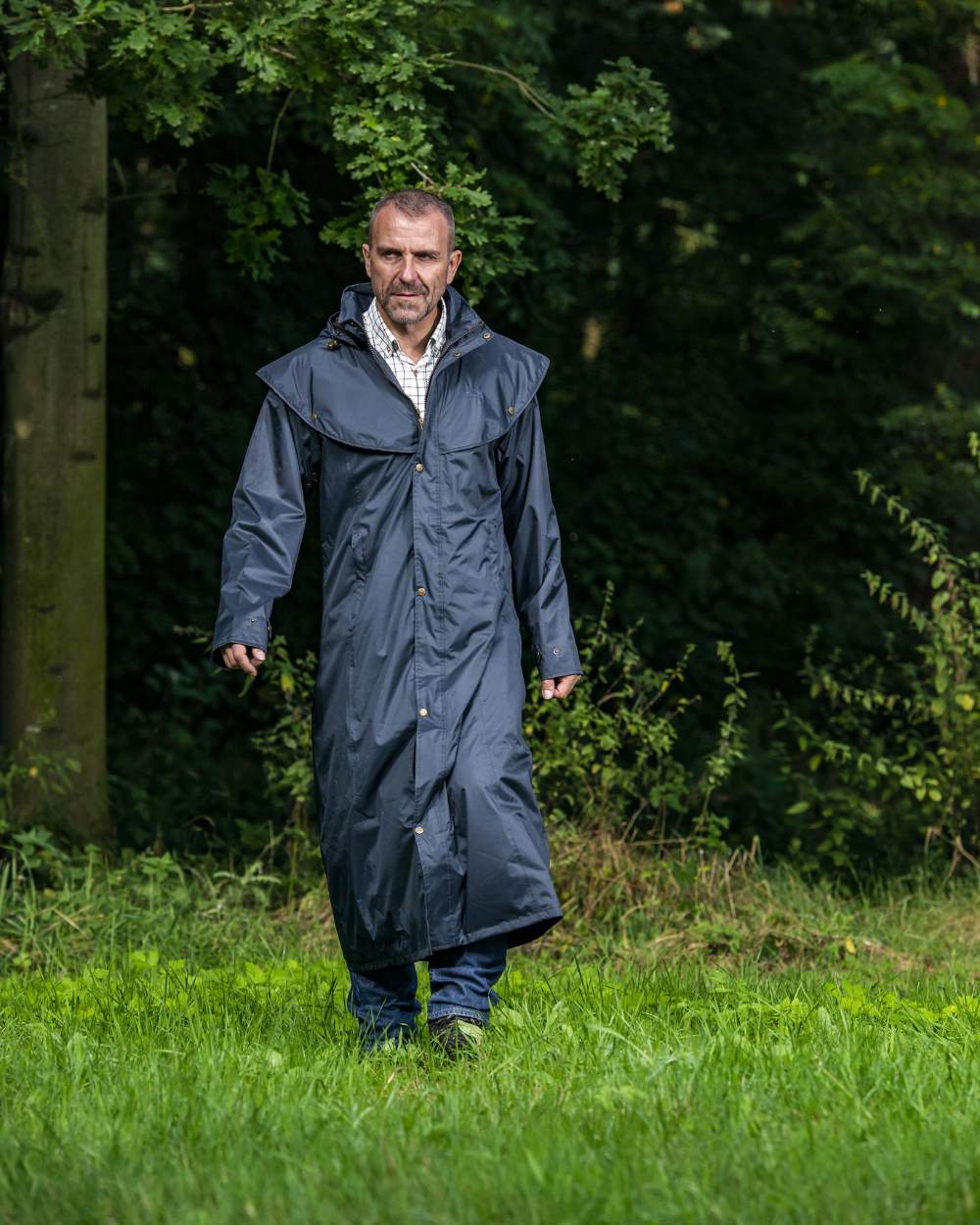 Navy Blue Coloured Baleno Newbury Waterproof Long Coat On A Forest Background