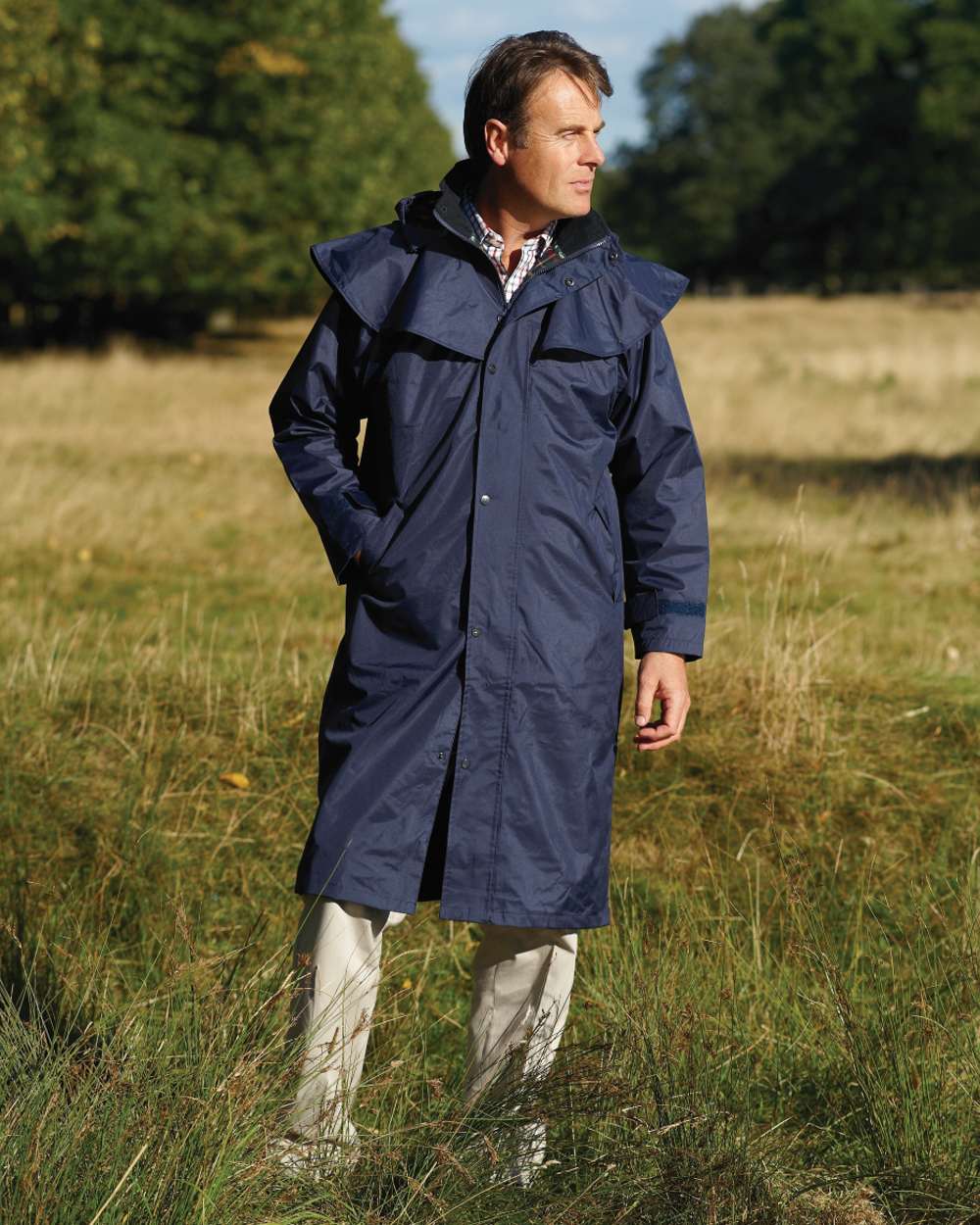 Navy Coloured Champion Highgrove Long Waterproof Coat On A Field Background