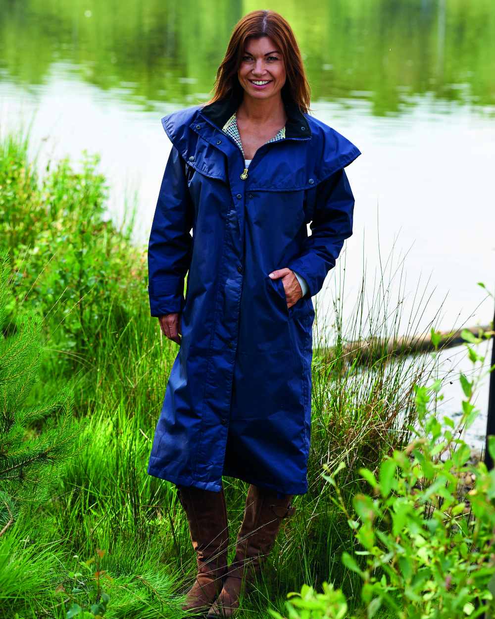 Navy Coloured Champion Sandringham Long Waterproof Coat On A Lake Background