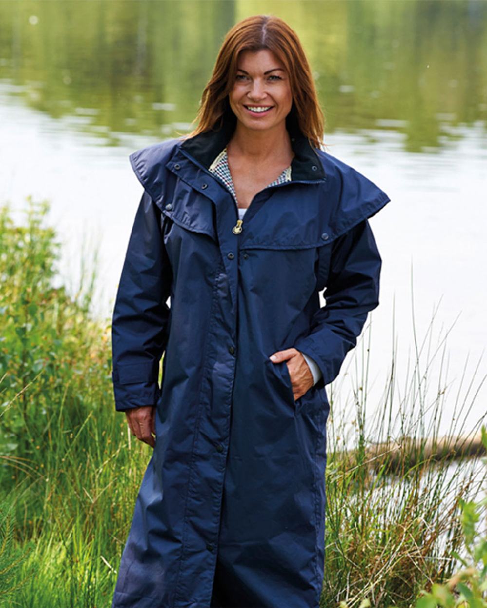 Navy Coloured Champion Sandringham Long Waterproof Coat On A river Background
