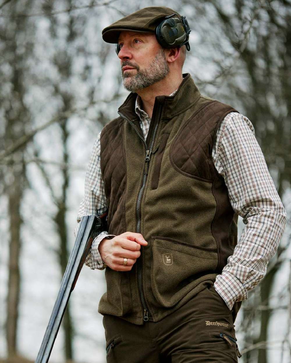 Tarmac Green coloured Deerhunter Eagle Flat Cap on forest background