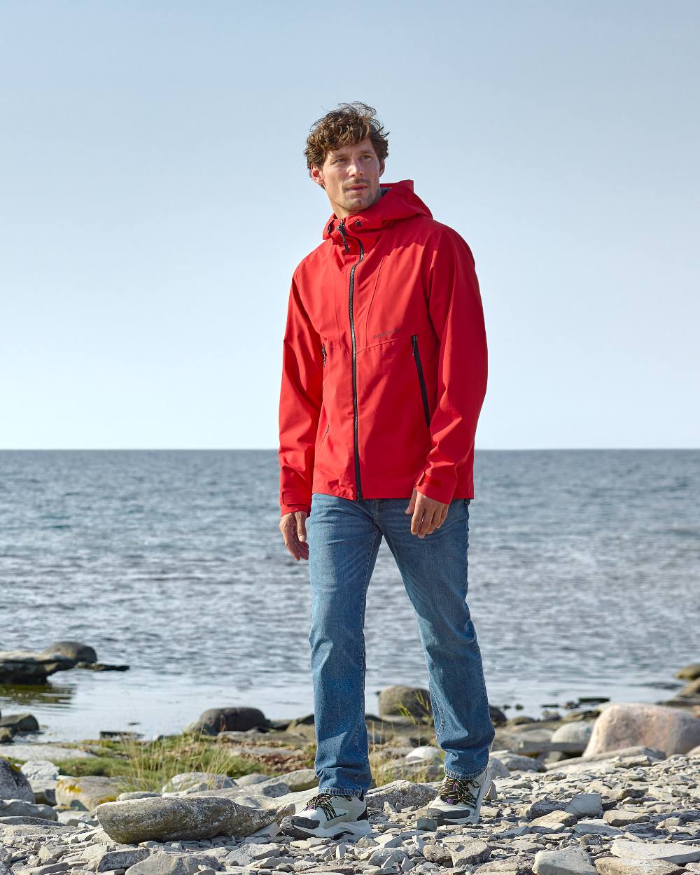 Pomme Red Coloured Didriksons Basil Unisex Waterproof Jacket 4 on Beach Background
