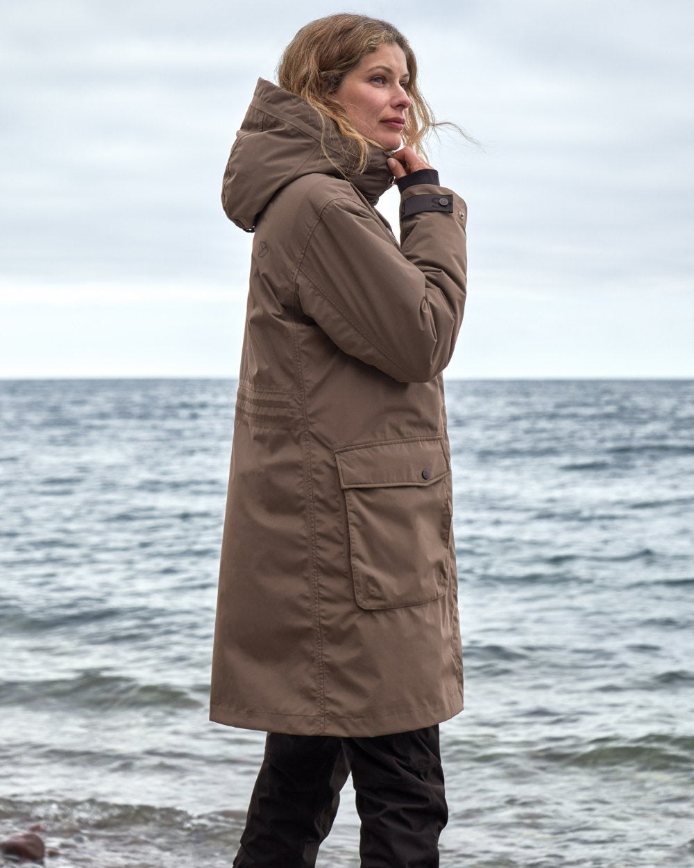 Mocha Brown Coloured Didriksons Womens Ilsa Parka On A Beach Background