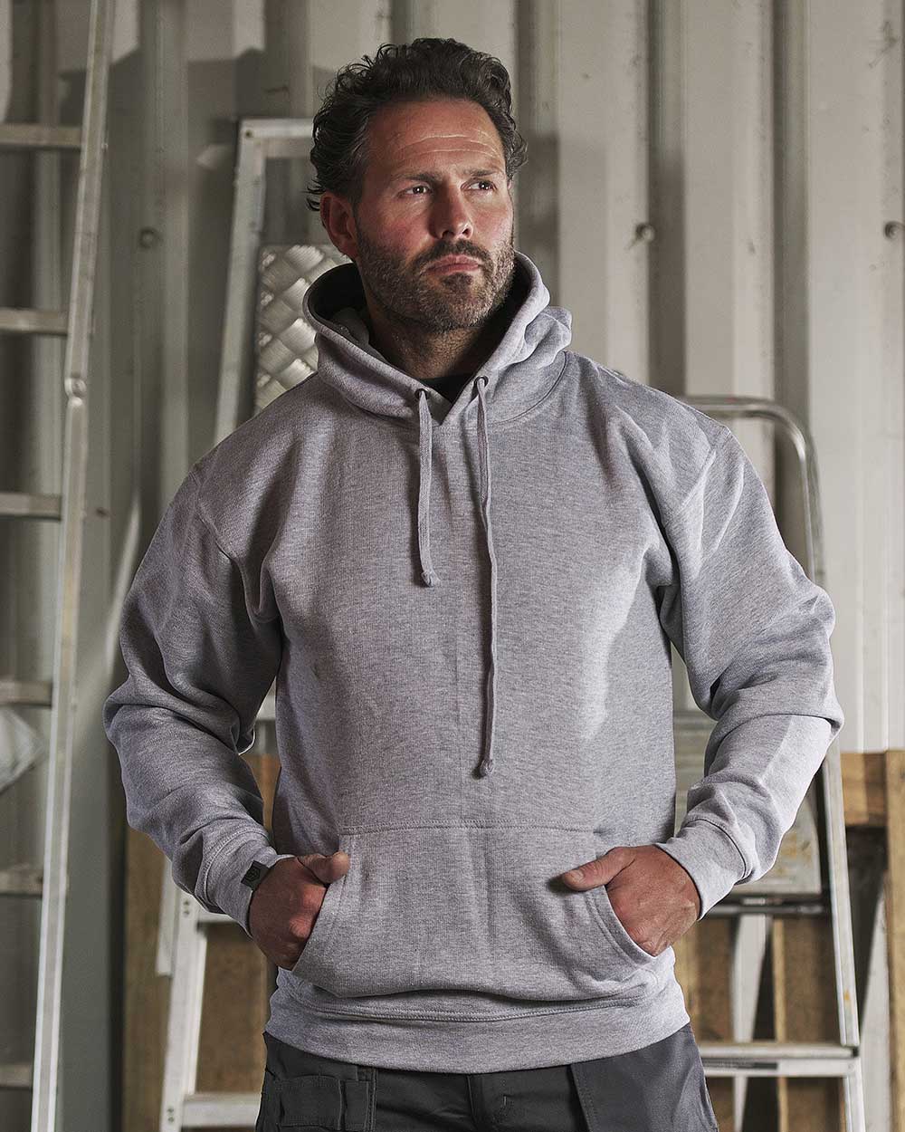 Man with hands in pockets wearing TuffStuff Hendon Hoodie in Grey  