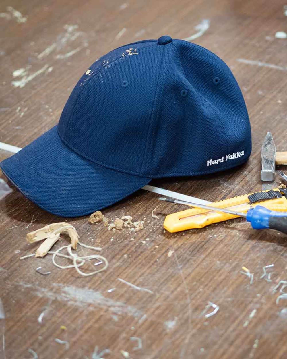 Navy Coloured Hard Yakka Flexfit Baseball Cap on Indoor Background