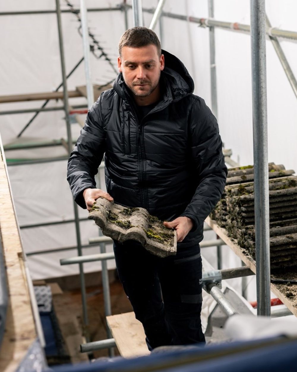 Black Coloured Hard Yakka Mens Puffa 2.0 Insulated Jacket on Construction Background