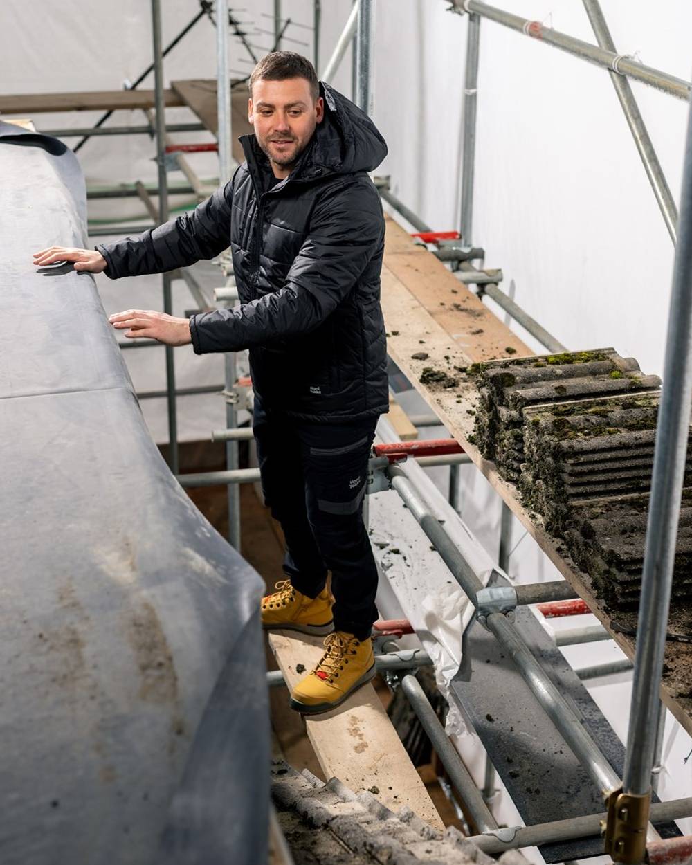 Black Coloured Hard Yakka Mens Puffa 2.0 Insulated Jacket on Construction Background