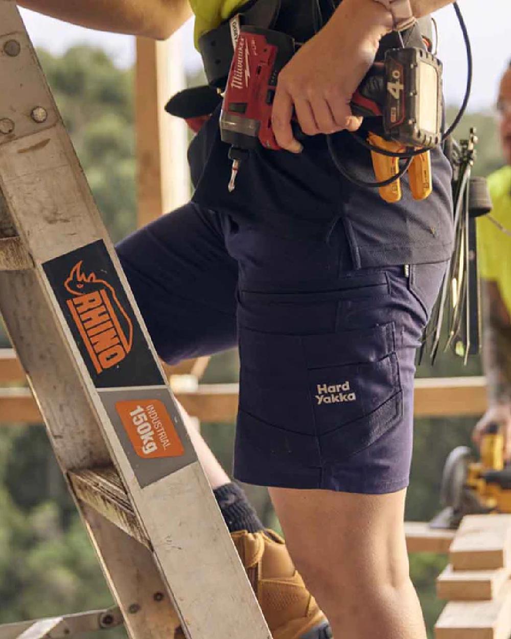Navy Coloured Hard Yakka Raptor Active Cargo Shorts on Blurry Background