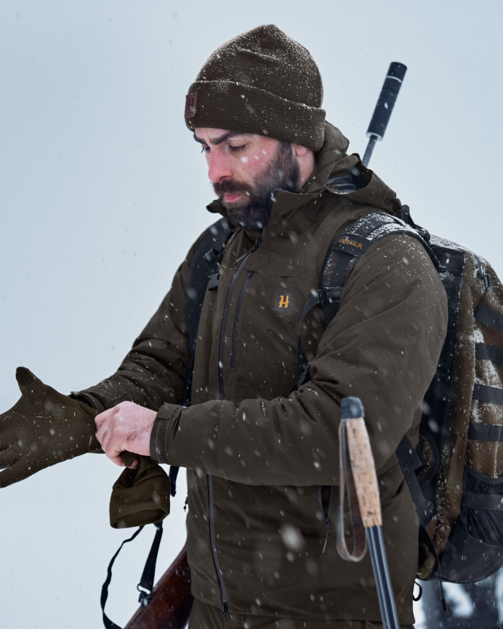 Willow Green Coloured Harkila Logmar HWS Packable Jacket on snow background