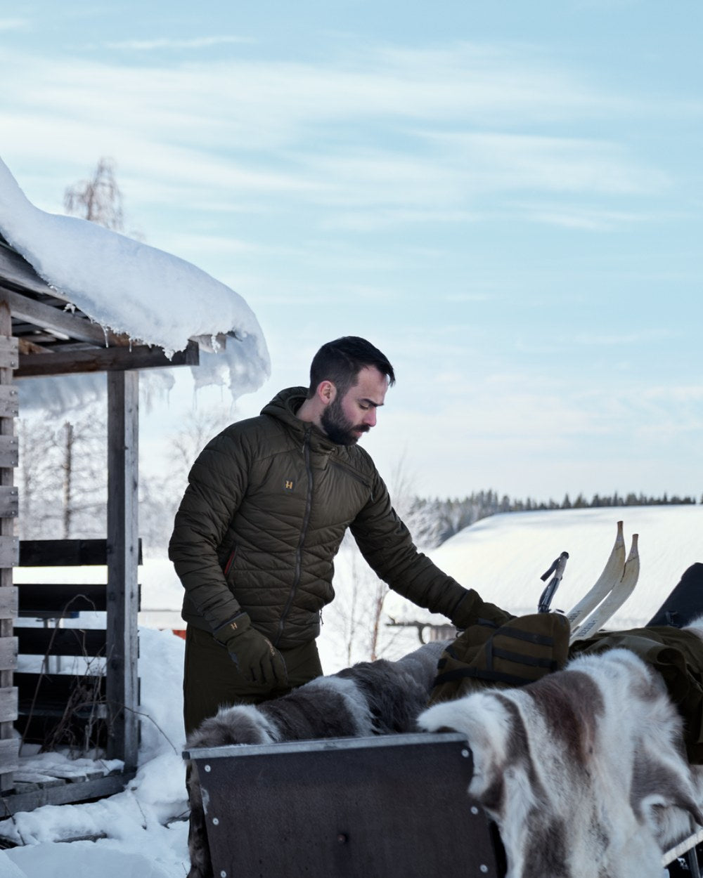 Willow Green Coloured Harkila Logmar Insulated Packable Hooded Jacket on snow background
