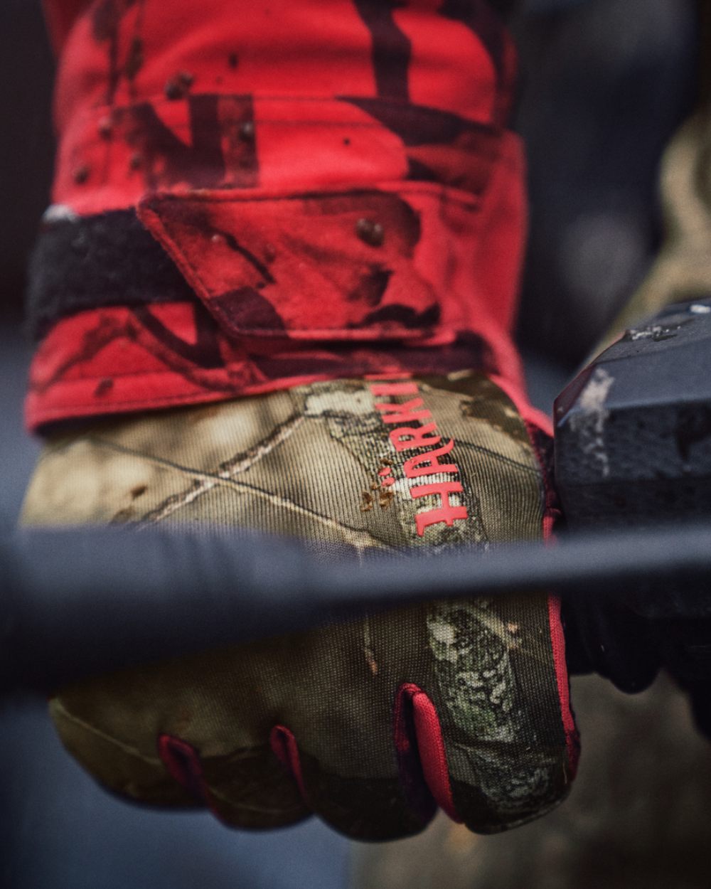 Mossy Oak Break Up Country Mossy Oak Red Coloured Harkila Moose Hunter 2.0 Fleece Gloves on blurry background