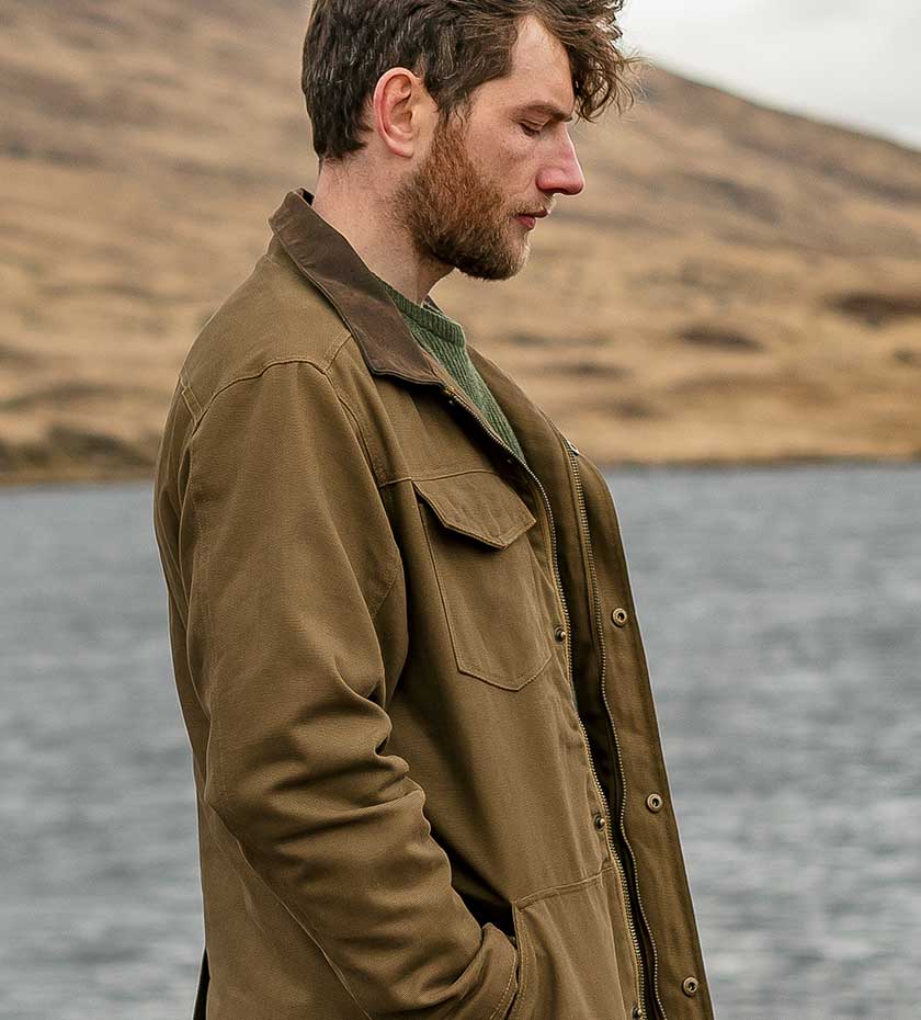 Man in Hoggs Khaki jacket with loch and hills in background.