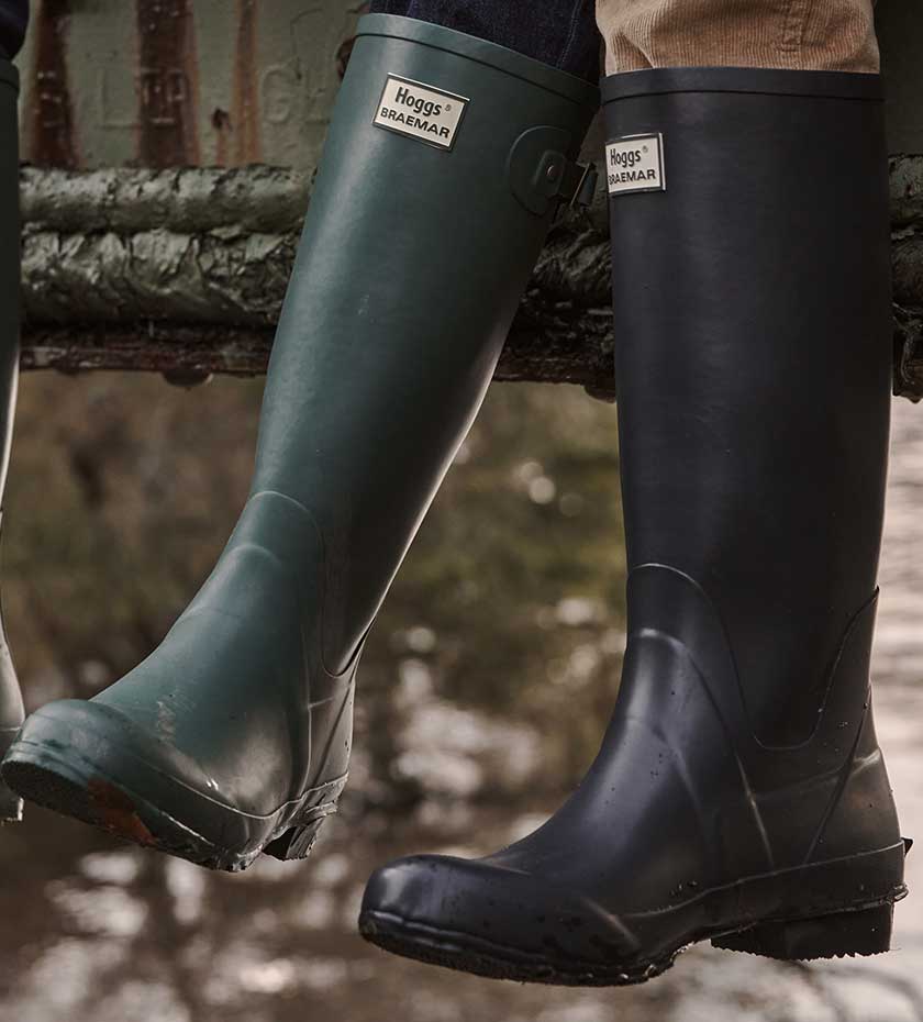 Hoggs of Fife rubber wellingtons in Navy and Green with water in background.