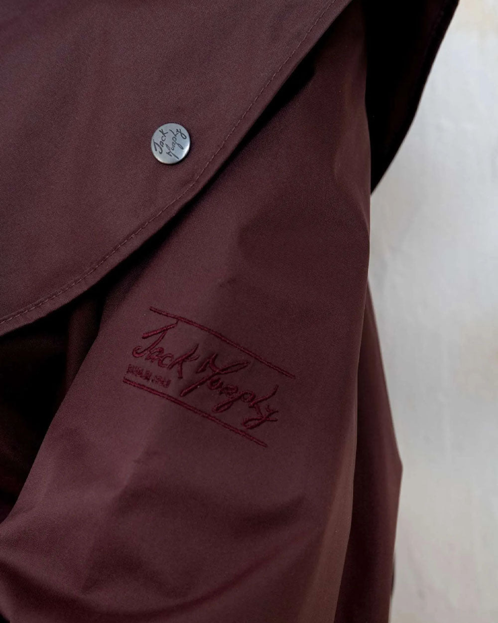 Deep Claret coloured Jack Murphy Cotswold Ladies Waterproof 3/4 Coat on wall background