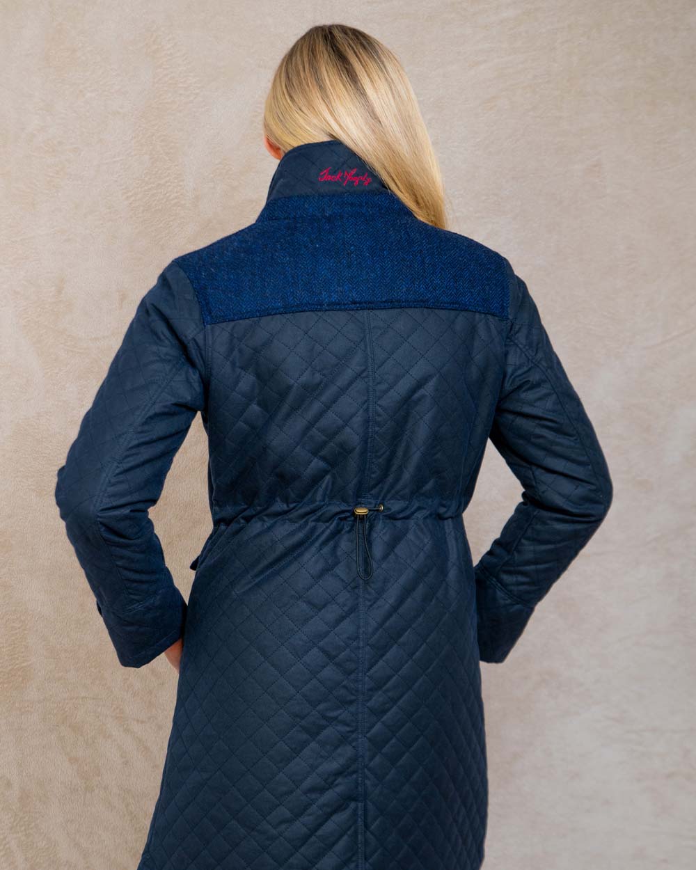 Navy coloured Jack Murphy Jodie Wax Coat on Pastel background