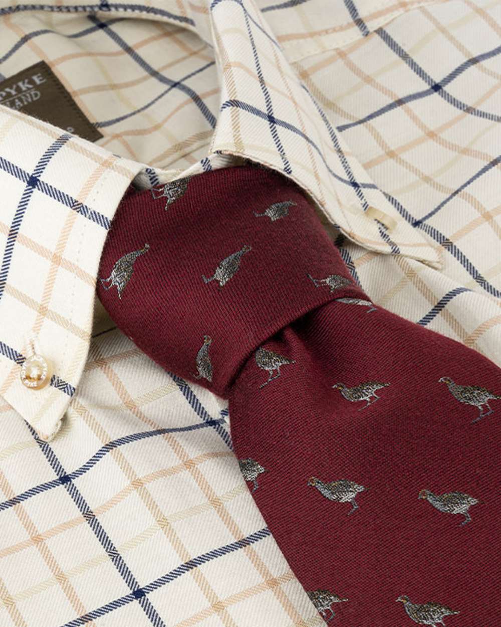 Burgundy coloured Jack Pyke Silk Tie Partridge on shirt background