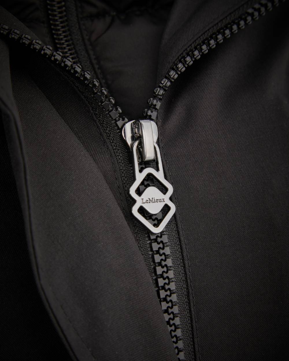 Black Coloured LeMieux Amelie Lightweight Waterproof Riding Coat On A White Background