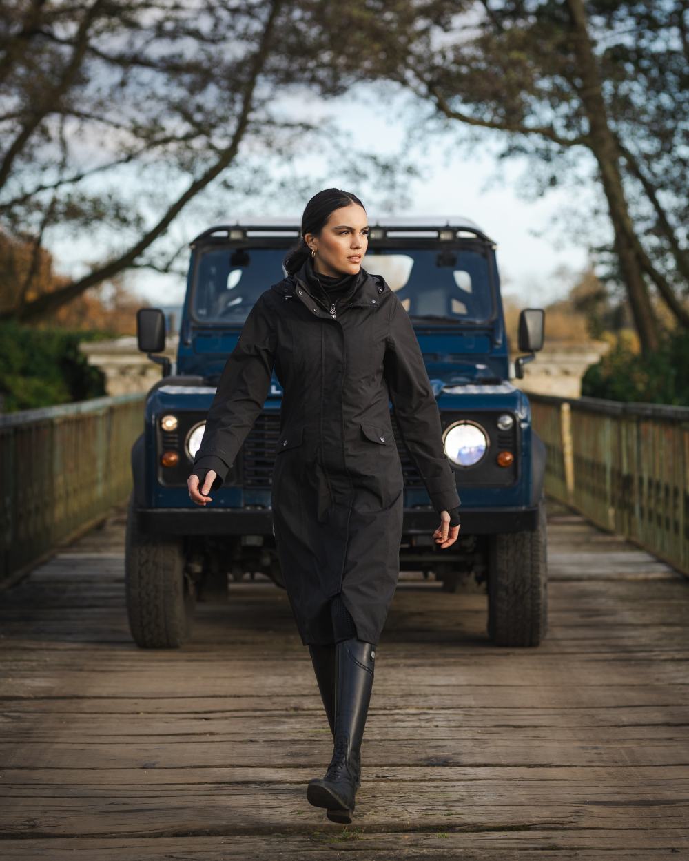 Black Coloured LeMieux Amelie Lightweight Waterproof Riding Coat On A Outer Yard Background