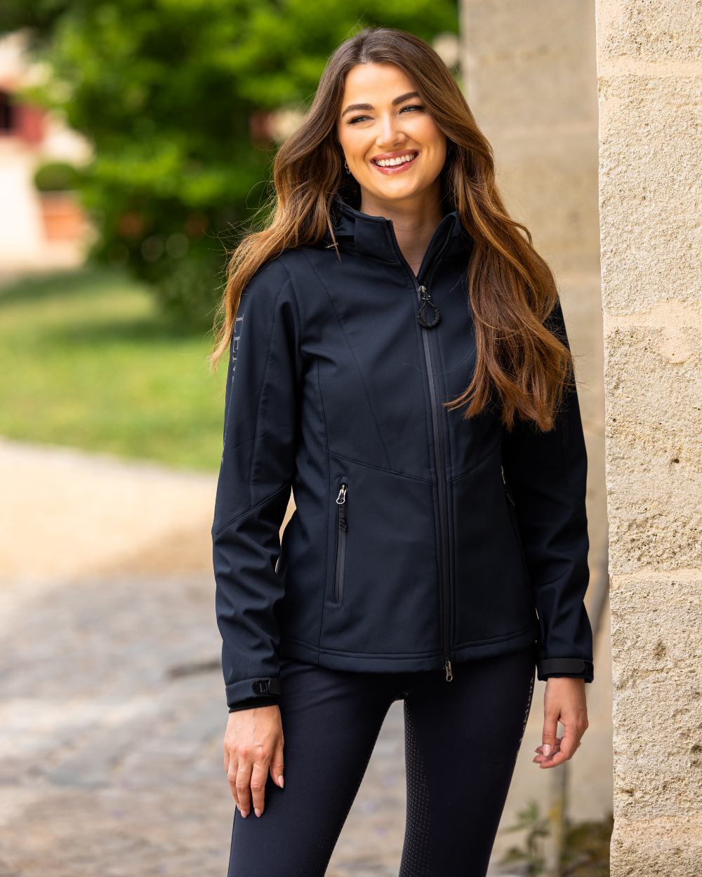Navy coloured LeMieux Celine Softshell Jacket on garden background
