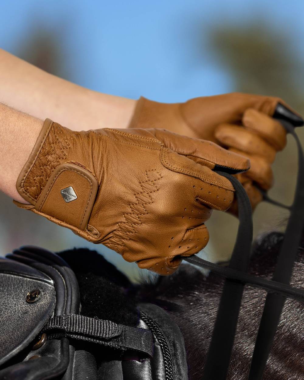 Tan coloured LeMieux Classic Leather Riding Gloves on horse background