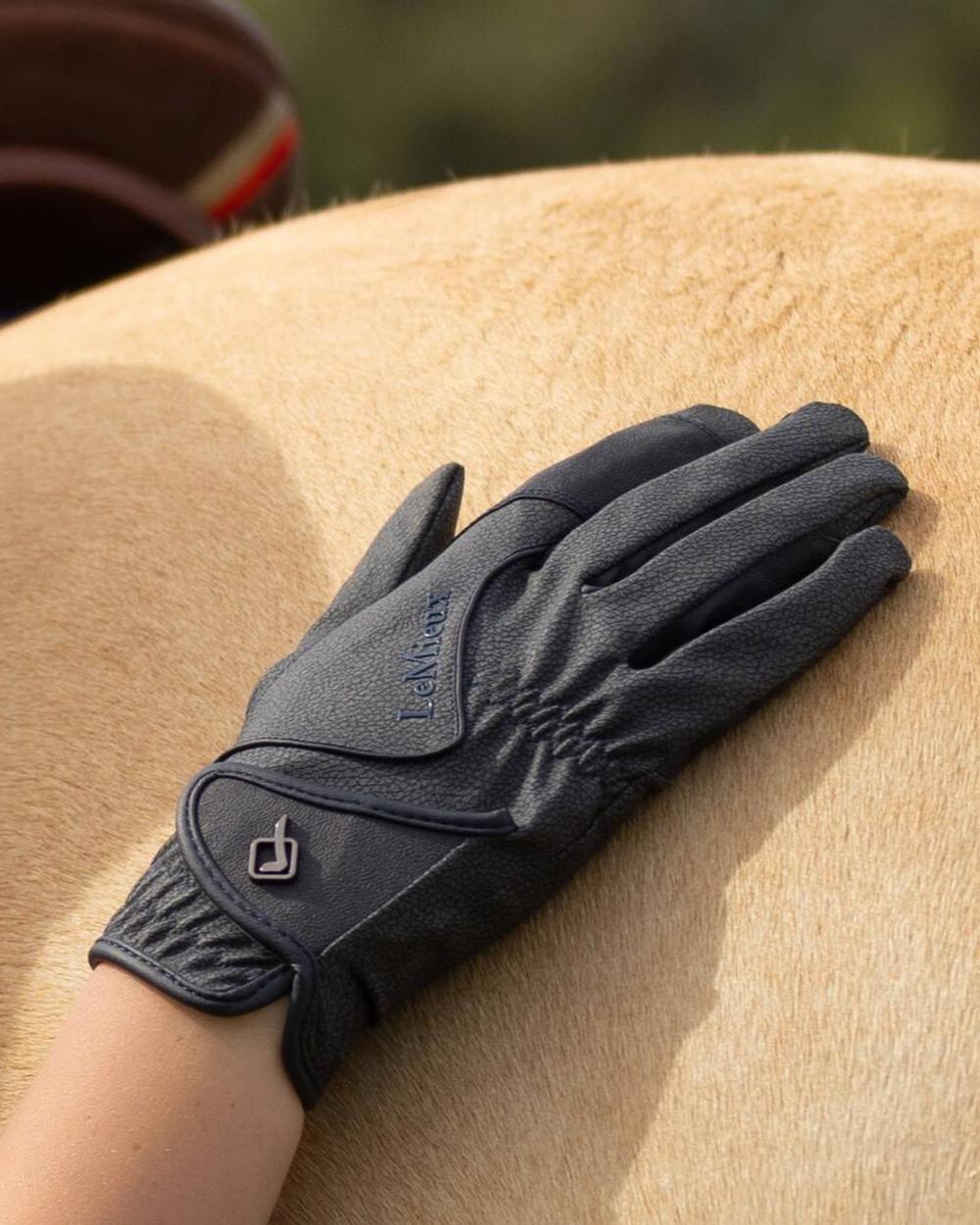 Navy coloured LeMieux Close Contact Gloves on horse background