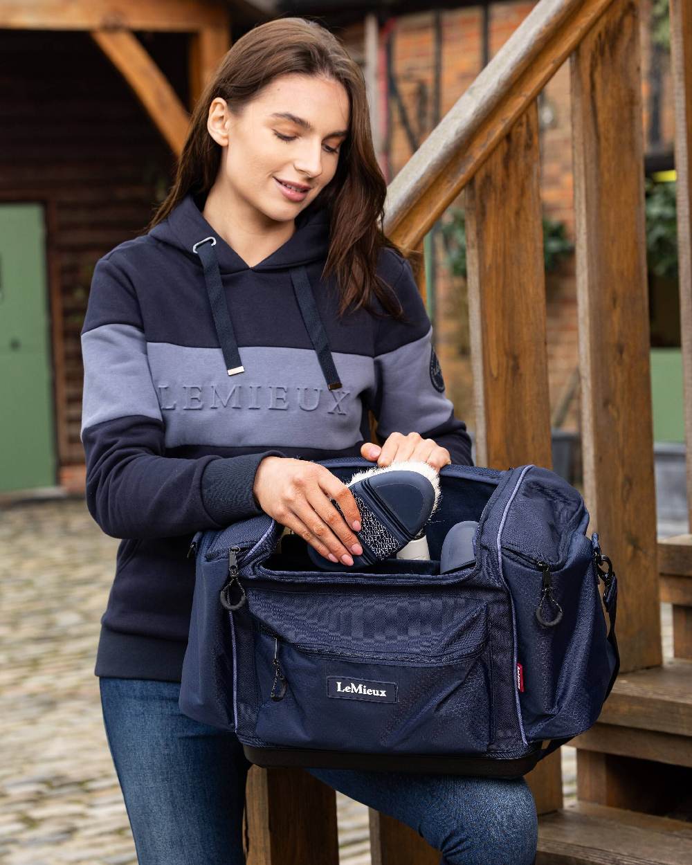 Navy coloured LeMieux Grooming Kit Pro on wooden stairs background