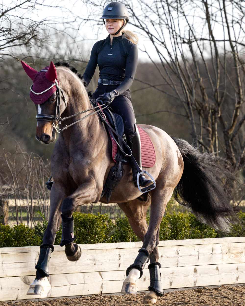 Black coloured LeMieux Mia Mesh Long Sleeve Base Layer with trees in background
