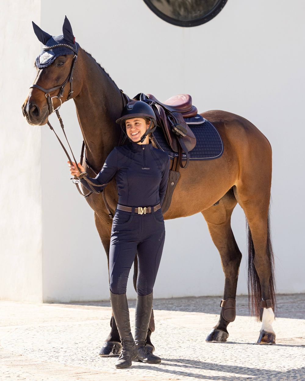 Navy coloured LeMieux Mia Mesh Long Sleeve Base Layer on grey wall background
