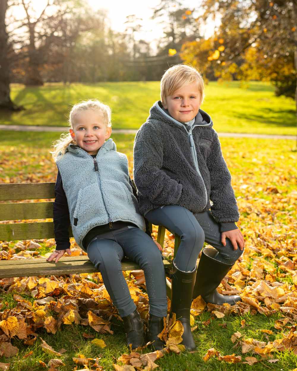 Petrol Coloured LeMieux Mini Teagan Fleece Jacket On A Outer Yard Background