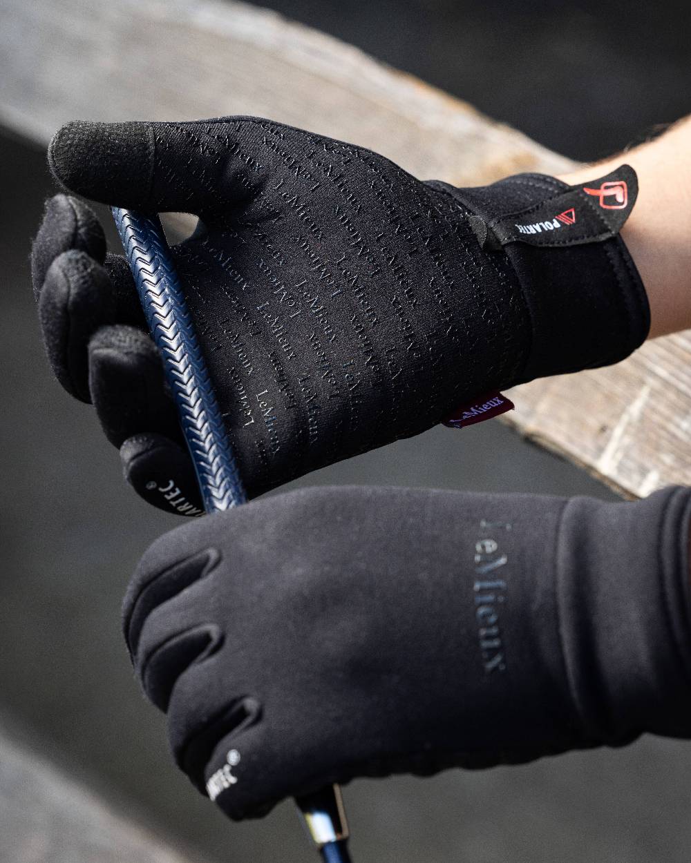 Black coloured LeMieux Polartec Gloves on grey background 