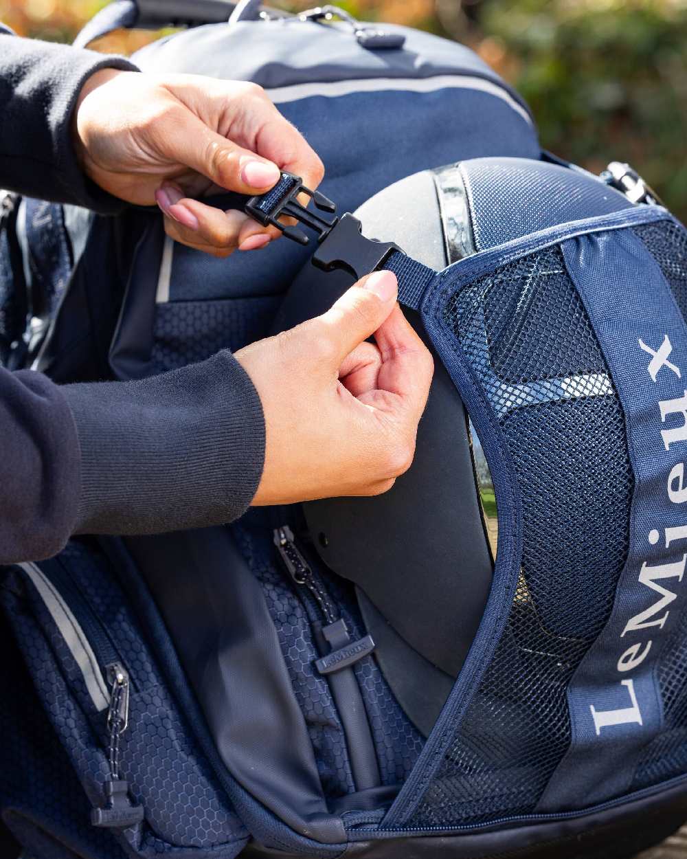 Navy coloured LeMieux Pro Rucksack on blurry background