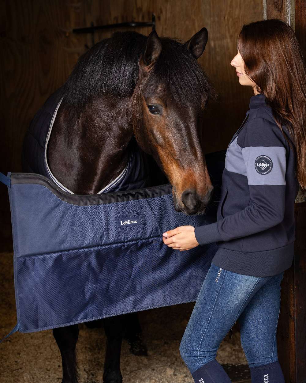 Navy coloured LeMieux Pro Stable Guard on stables background