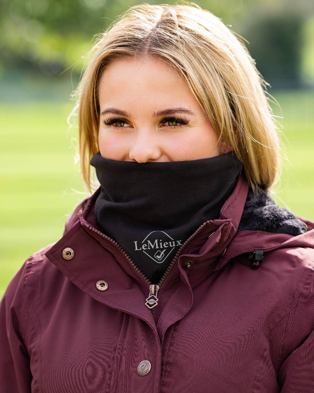 Black coloured LeMieux Stretch Snood on blurry green background 