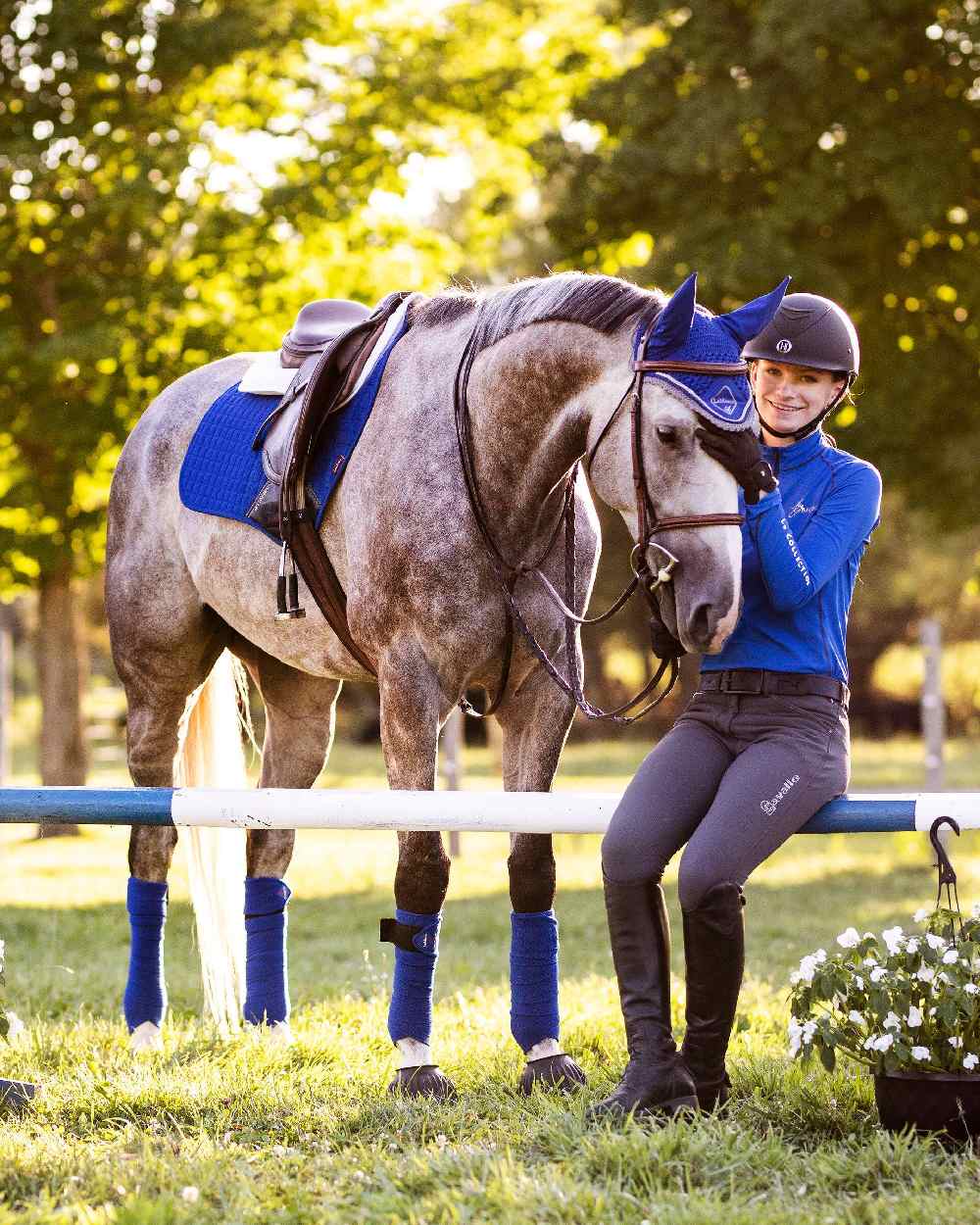 Benetton Blue coloured LeMieux Suede Close Contact Squares on show jumping background