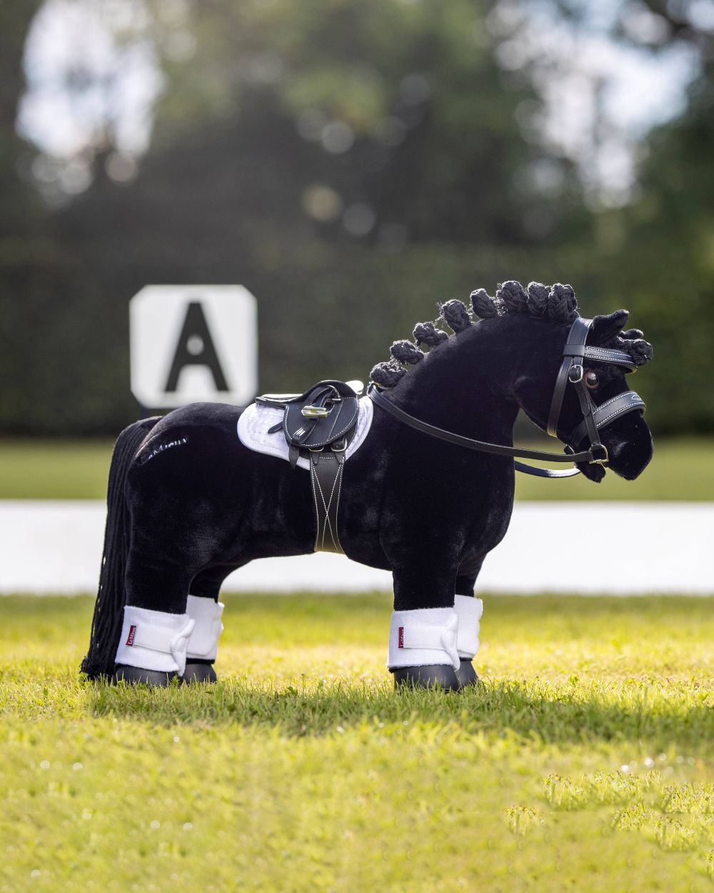Black coloured LeMieux Toy Pony Bridle on blurred green background