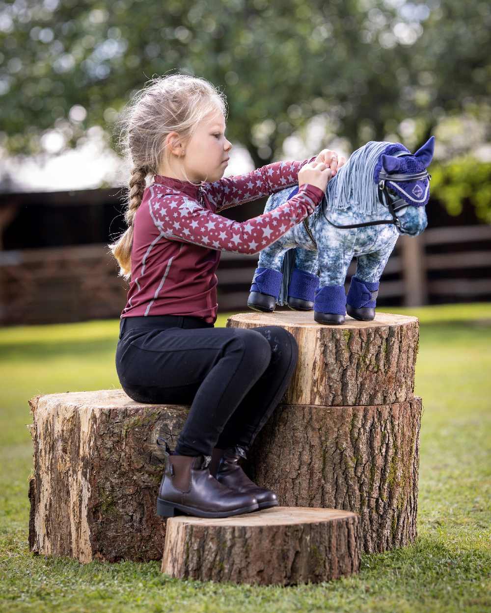 Black coloured LeMieux Toy Pony Bridle on blurred green background