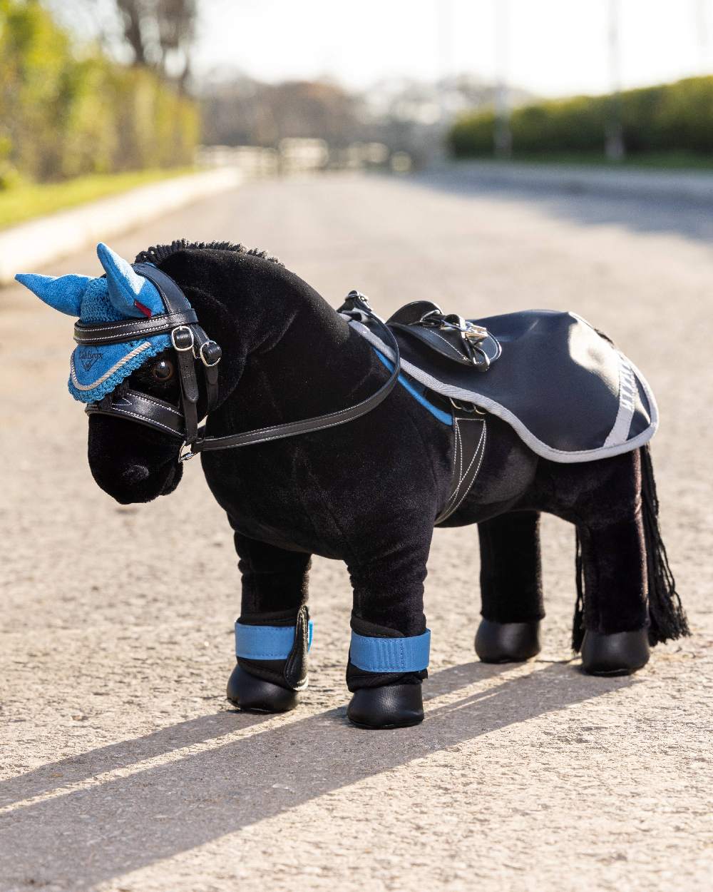 Navy coloured LeMieux Toy Pony Exercise Sheet on blurry grey background