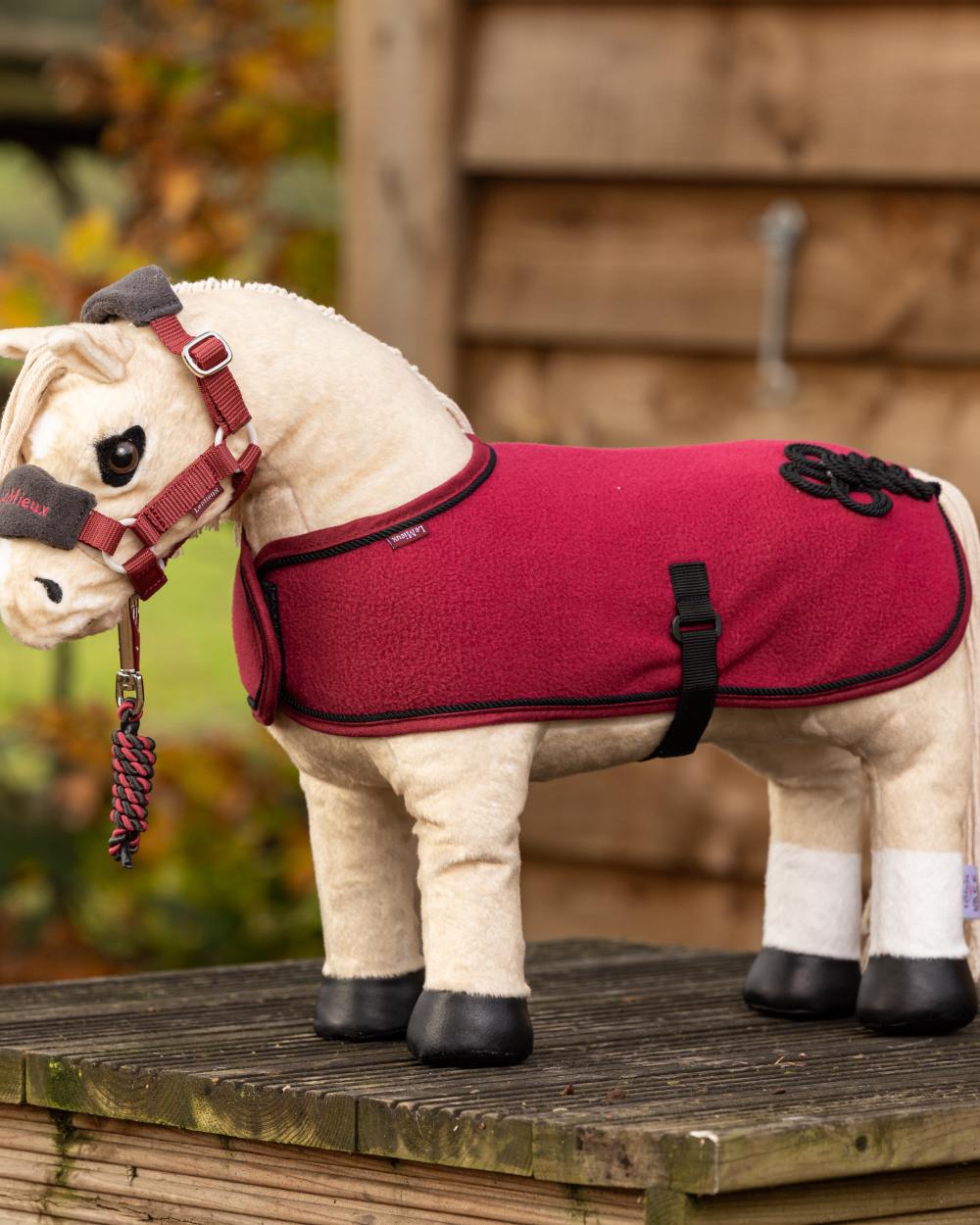 Ember Coloured LeMieux Toy Pony Rug On A Outer Yard Background