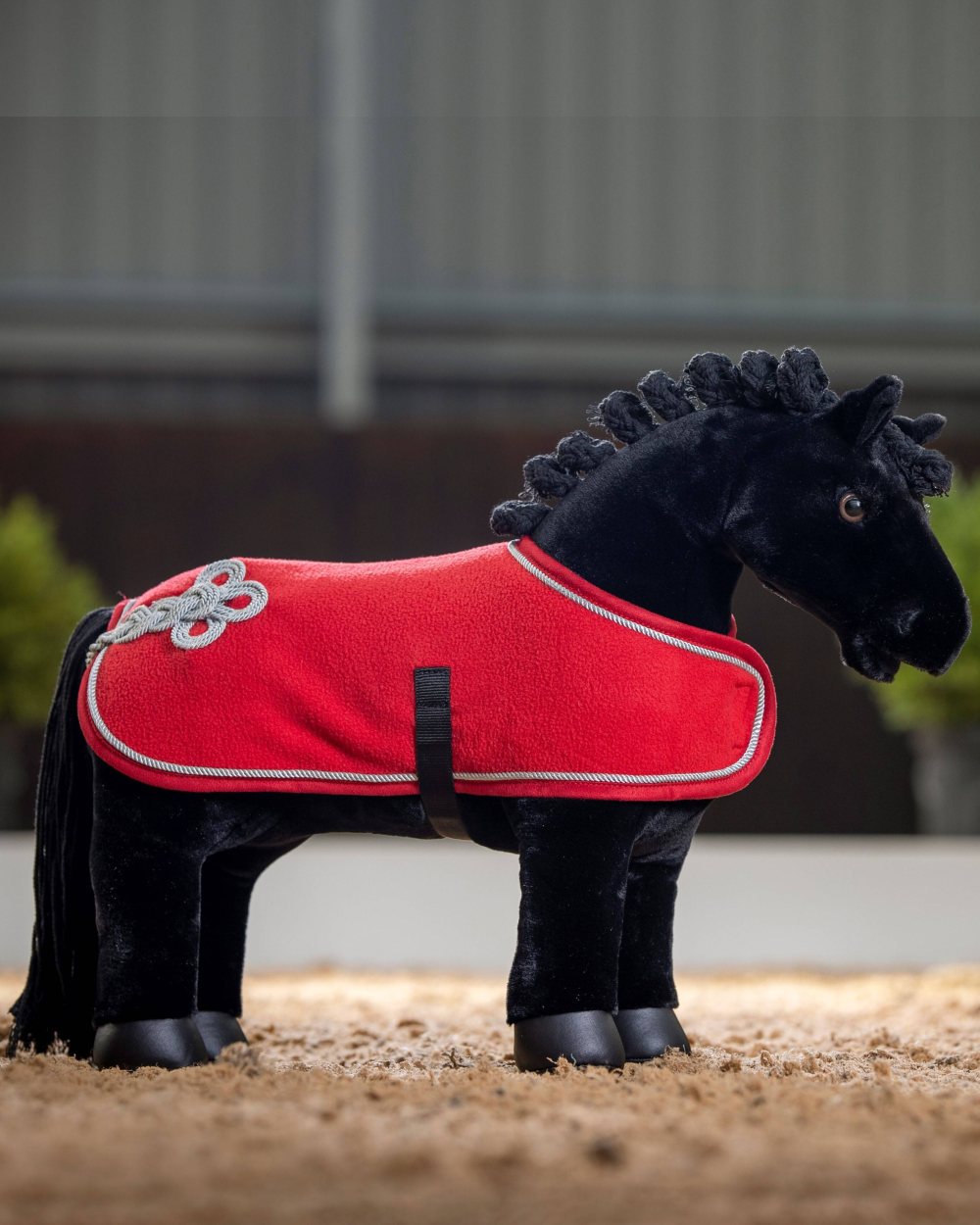 Chilli coloured LeMieux Toy Pony Rug on blurry grey background
