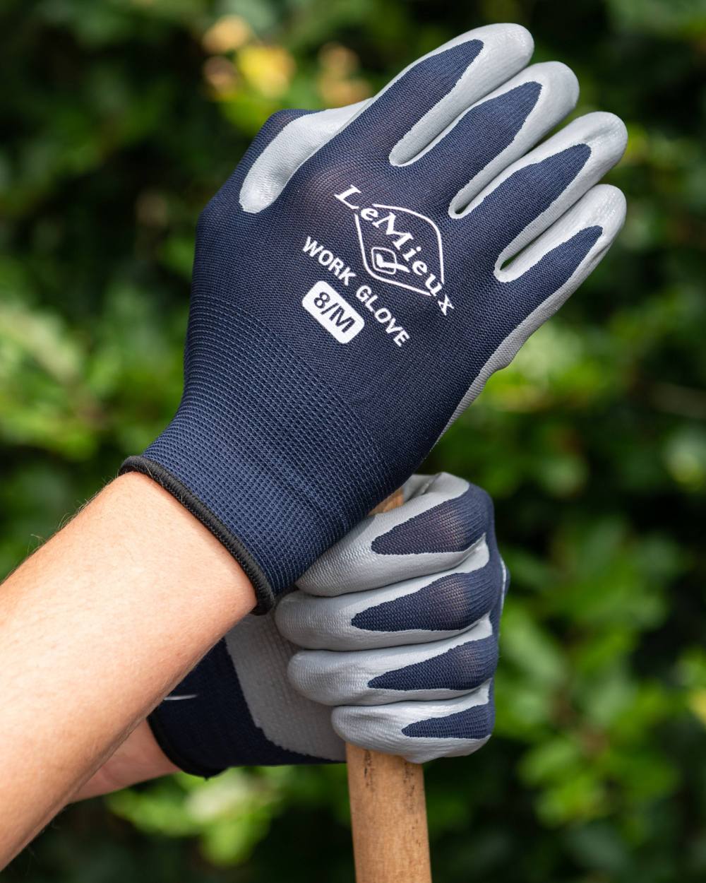 Navy coloured LeMieux Work Gloves on green background