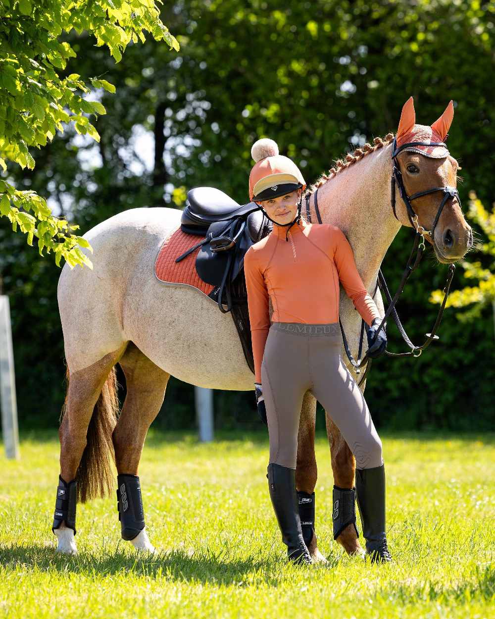 Apricot coloured LeMieux Young Rider Base Layer on green background